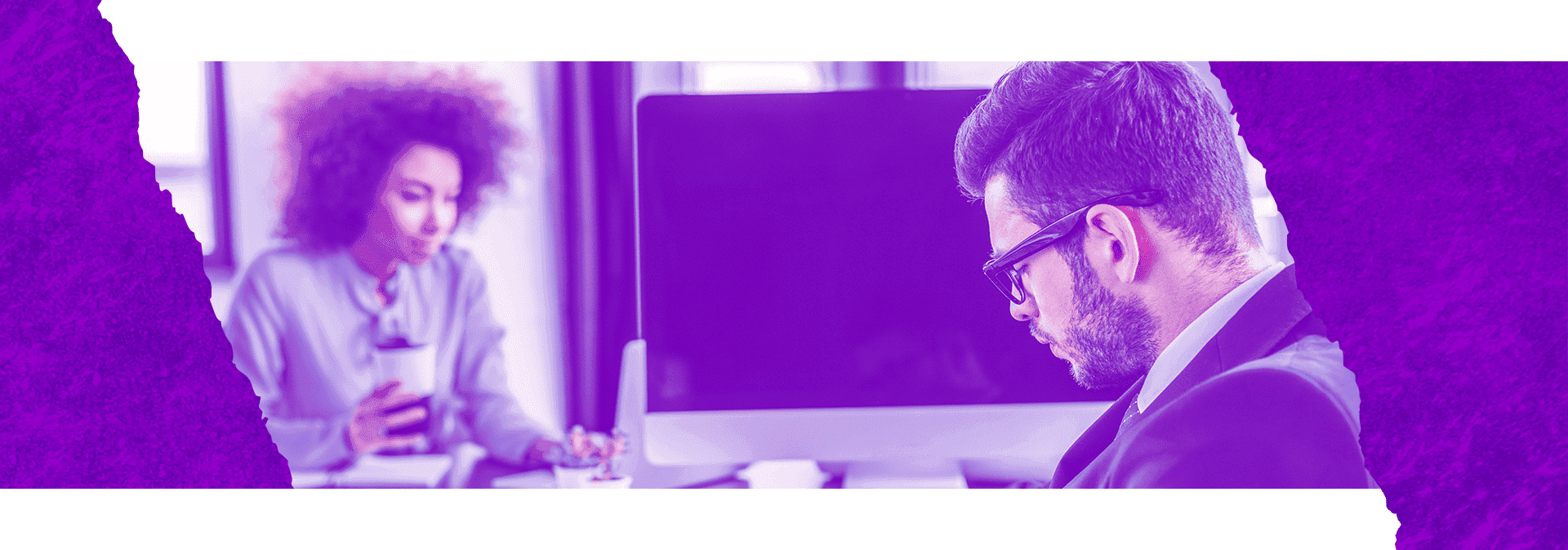 Imagem mostra 2 pessoas, 1 pessoa olhando para baixo e outra olhando para a tela do computador