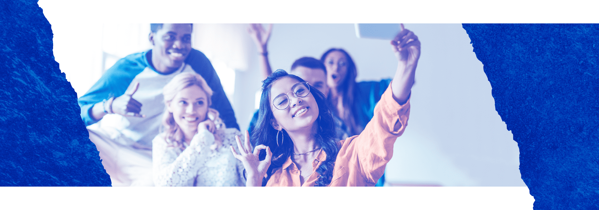 Imagem com bordas azuis, mostra 5 pessoas, uma dela esta segurando um celular para tira um self do grupo