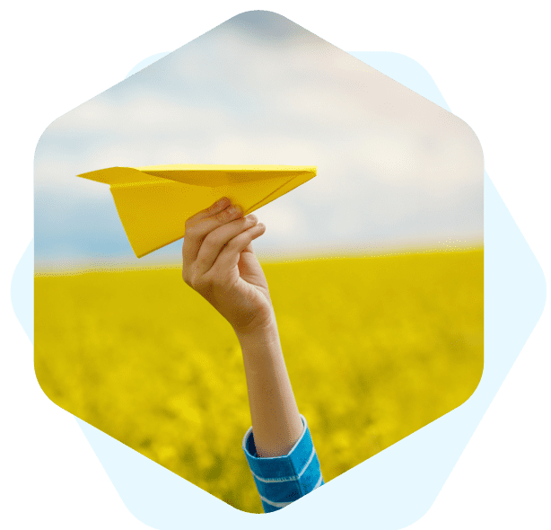 Uma mão segurando um aviãozinho de papel amarelo